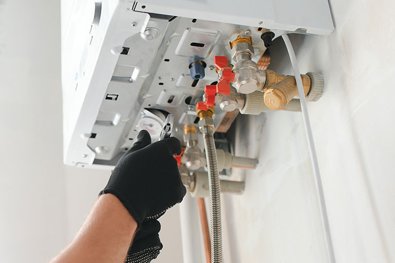 Gas Safe engineer fitting boiler pipework and valves during a new boiler installation in Norwich